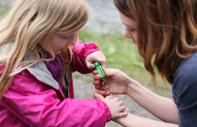 Een meisje en haar moeder bekijken samen de schat die ze tijdens de GeoTour hebben ontdekt.