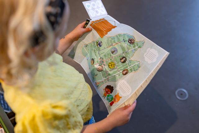 Een kindje die een folder vasthoudt over streekproducten uit de Beemster