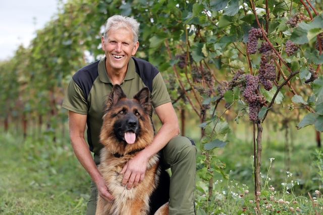 Wijngaardhouder Hans met hond in de wijngaard By Ypma