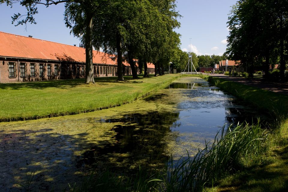 Een deel van het Gevangenismuseum en de gracht op een zomerse dag in gevangenisdorp Veenhuizen.