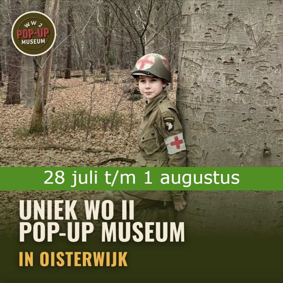 Foto van een jongetje in soldatenkleding met groene helm en met een witte band met rood kruis zowel op de helm als op zijn arm. Hij staat tegen een boom geleund in een herfstbos.