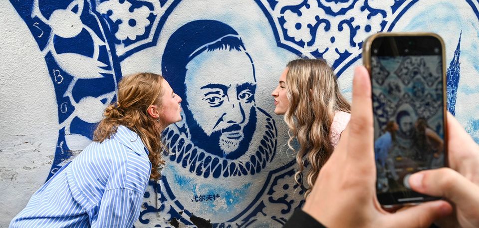 Twee meiden die poseren bij de Willem van Oranje in de Bonte Ossteeg in Delft