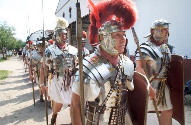 Romeinse soldaten in vol harnas marcheren in formatie tijdens een historisch festival in Archeon, als onderdeel van een levende geschiedeniservaring in het Groene Hart.