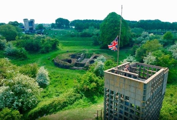 Restanten van het oude Fort Sint Andries, op de voorgrond de oude luchtwachttoren met mensen erop en een Engelse vlag