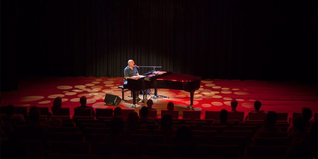 Een man die achter de piano zit op het podium van Theater de KunstGreep