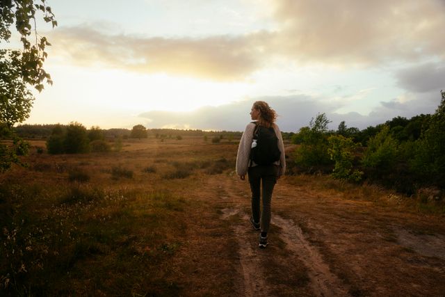 Eine Frau wandert durch weitläufige Natur.
