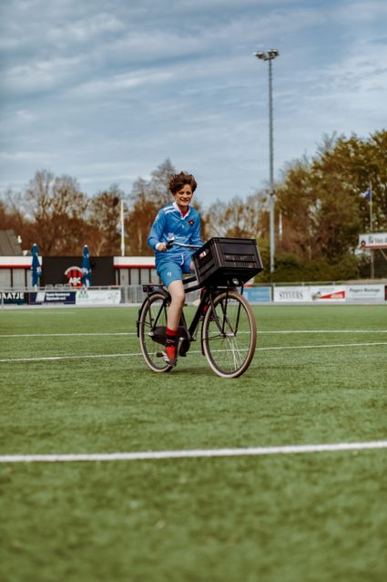 Jongen fietst op het voetbalveld in sportkleding