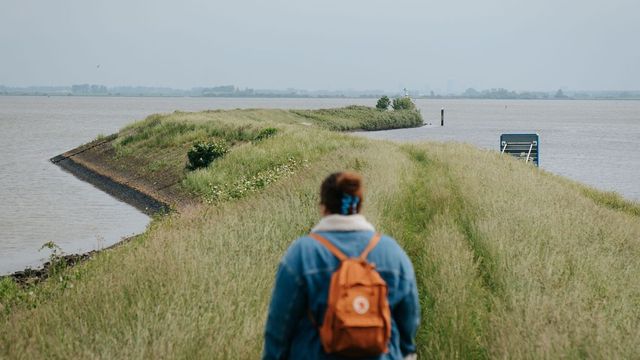 Vrouw wandelt over de groene dijken bij het Havenhoofd in Middelharnis