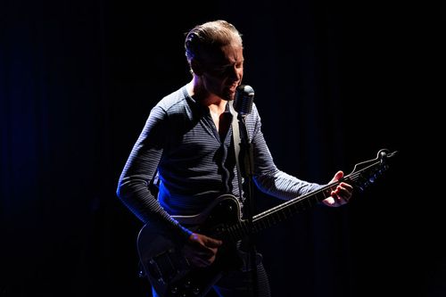 Man aan het optreden met een gitaar