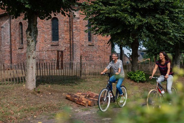 Ein Paar radelt durch ein Drents Brinkdorf.