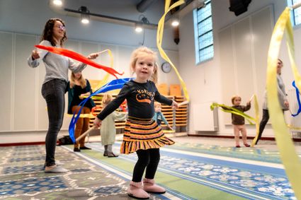 Kinderen dansen met kleurrijke linten tijdens een kinderactiviteit in Het Klooster in Woerden.