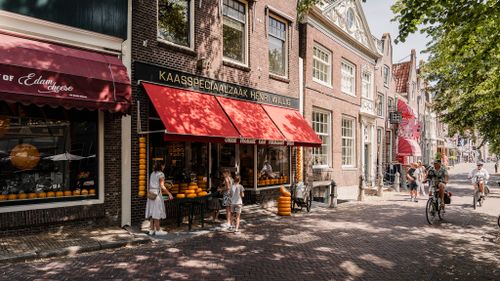 Een gezin die bij de Henri Willig kaasspeciaalzaak staan in Edam