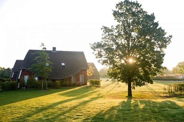 Een luxe bungalow op een vakantiepark bij ondergaande zon.