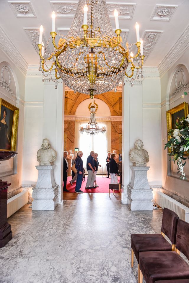 Een groep mensen krijgt een rondleiding in Paleis Soestdijk