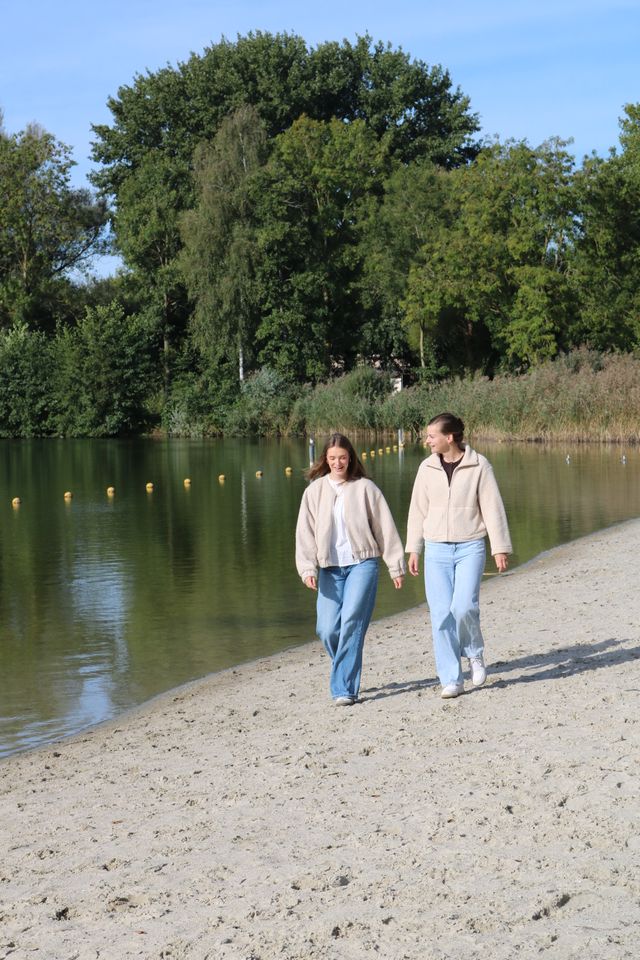 Twee vrouwen lopend op het strand van recreatiegebied Meren van Borculo