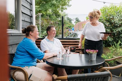 Een man en vrouw zitten op het terras van Eethuis de Polder