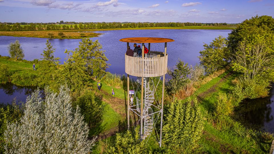 Uitkijktoren Hollandse IJsselpad in de Utrechtse Waarden, Groene Hart. Bezoekers genieten van het uitzicht over plassen, wandelpaden, rietkragen en het waterrijke natuurgebied vanaf de uitkijktoren.