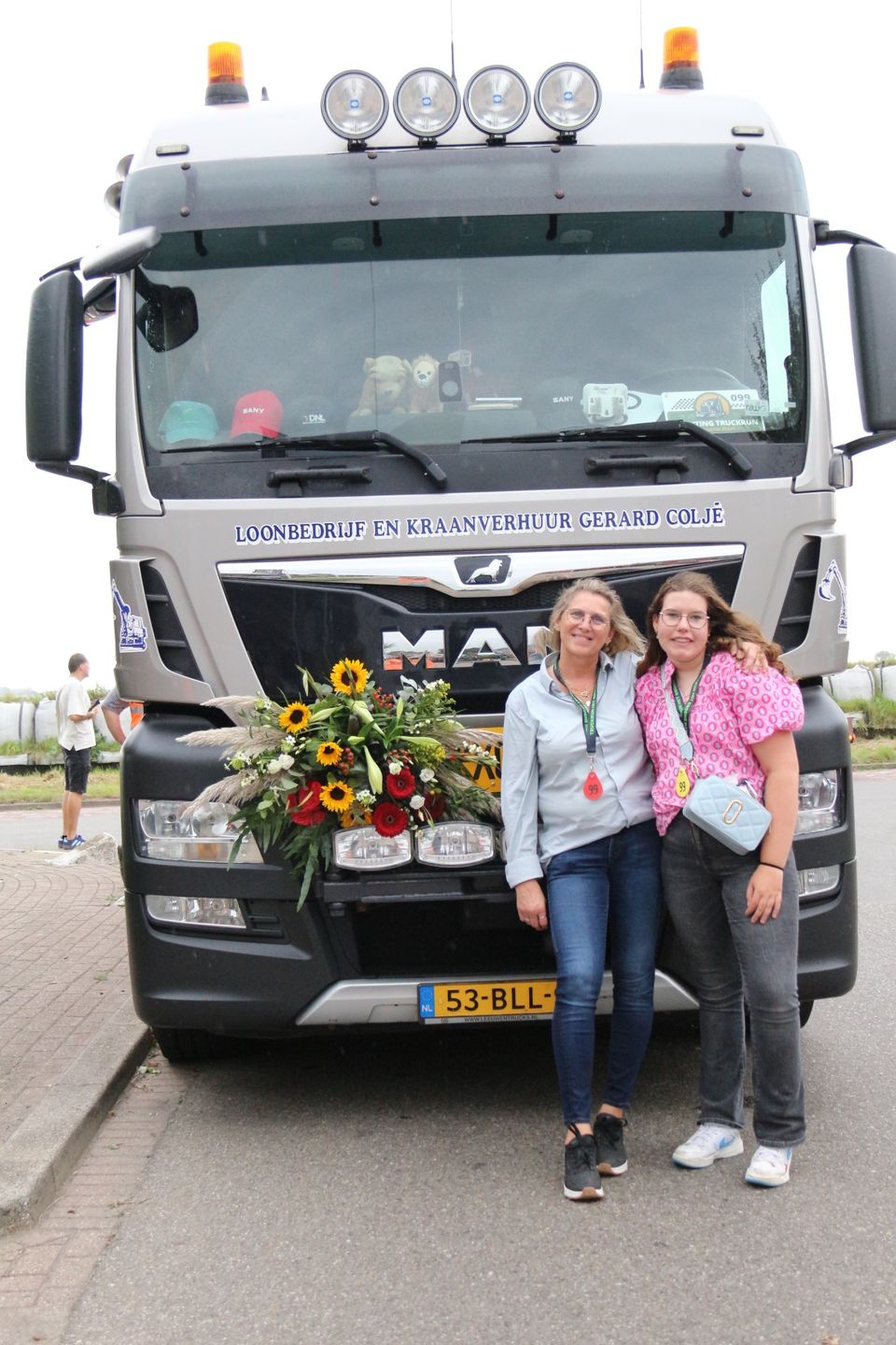 Twee deelnemers poseren voor een versierde MAN-vrachtwagen tijdens de Truckrun Groene Hart.