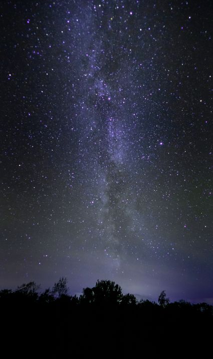 Een foto van de hemel bij nacht met mooie kleuren en veel sterren.