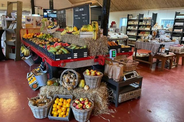 Een tafel en aardappelkistjes met verse groenten en fruit in een boerderijwinkel in Drenthe.
