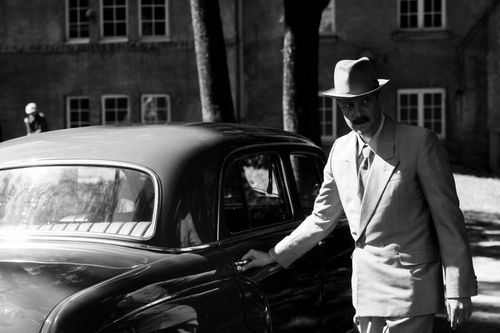 Zwart wit foto van een man bij een oldtimer