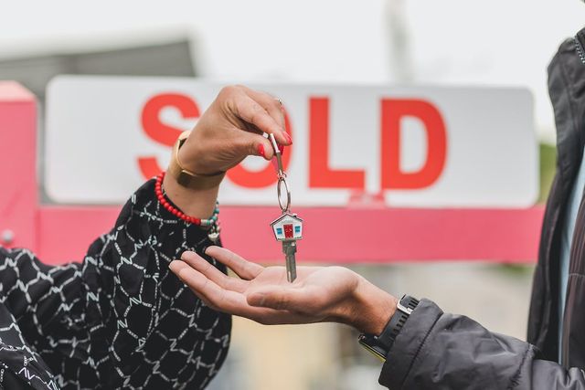 Picture of someone handing house keys to another person