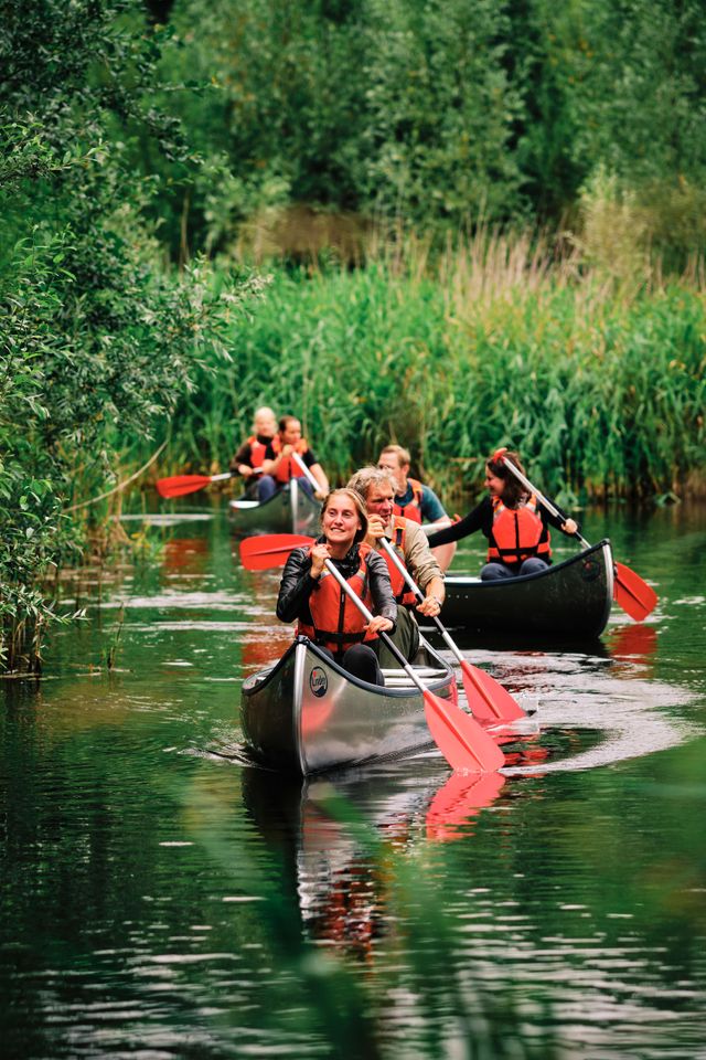 Groep mensen op water in kano's.