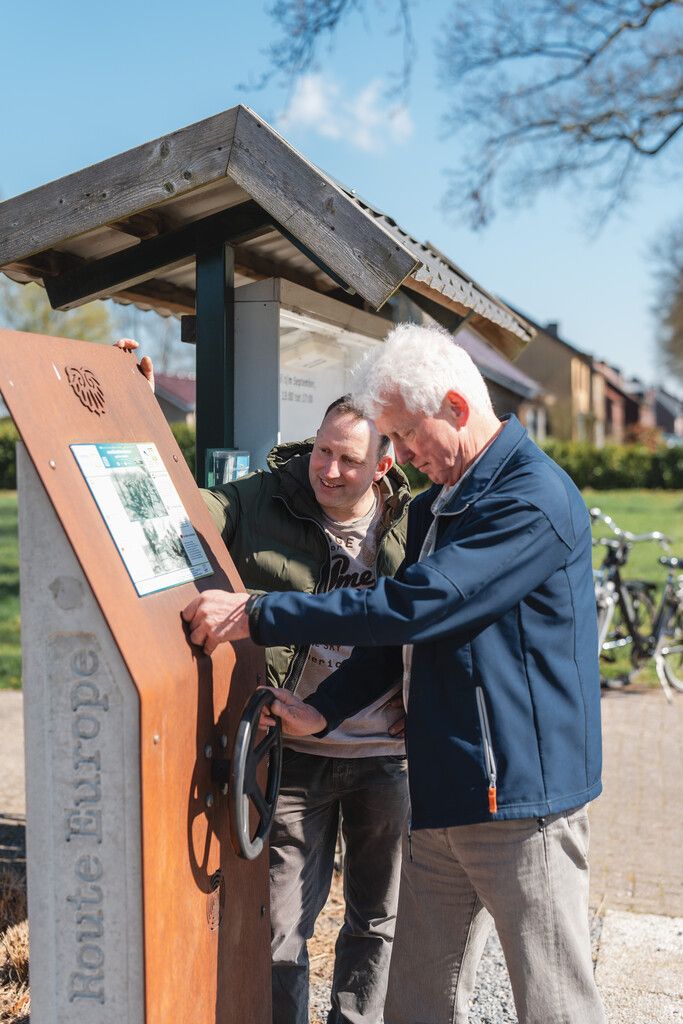 Fietsers staan bij de luisterzuil bij Stichting Militair Historisch Museum Achtmaal