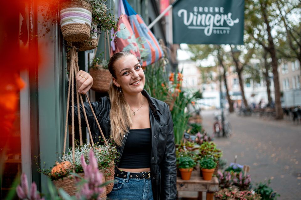 Jonge dame die winkel Groene Vingers uitloopt