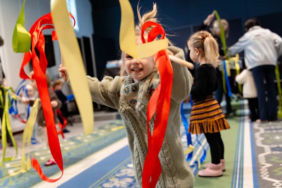 Kinderfestival met spel en beweging, vrolijk spelend peuter met kleurrijke linten in Het Klooster, Woerden, Groene Hart, actief en creatief moment tijdens een cultureel kinderprogramma.