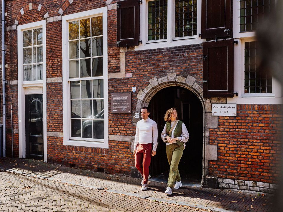 Koppel die uit een historisch huis in Delft komt lopen