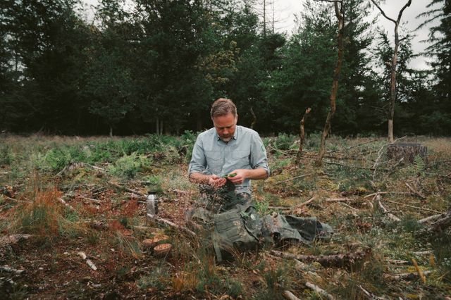 De boswachter laat tijdens een wildplukwandeling zien welke planten eetbaar zijn.