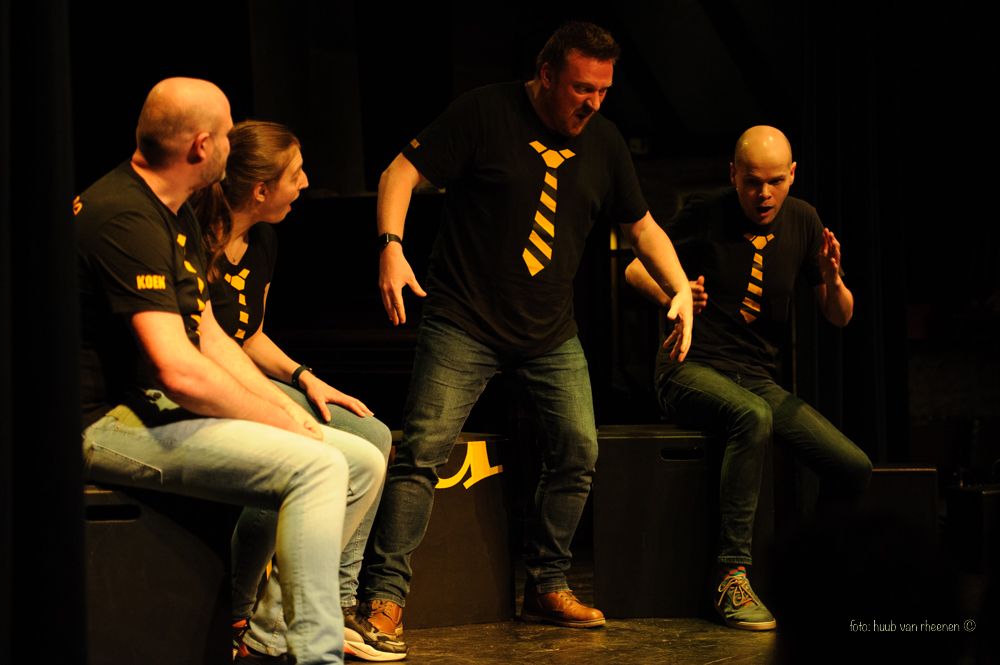 Het team van Allure geel actief op het podium. Met zwart gele shirts en grappige poses.