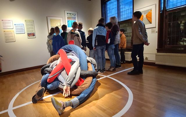 Museum Stadsmuseum Woerden bij Defensie Eiland in het Groene Hart, kinderen bekijken een tentoonstelling tijdens een educatieve LEGO workshop, met interactieve kunstinstallatie op de voorgrond in historische museumzaal.