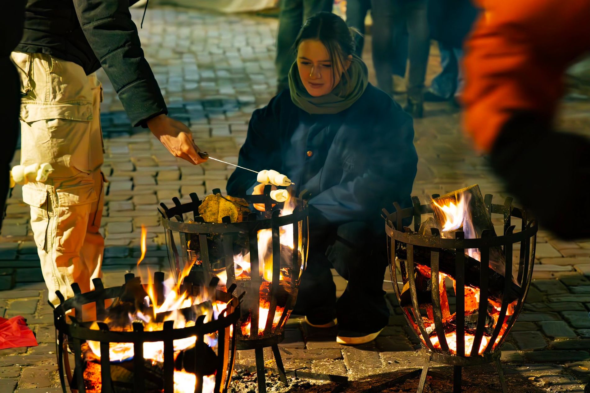 Bezoekers maken marshmallows op een vuurtje.