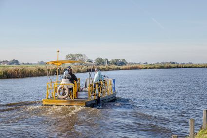 Geel pontje dat net met passagiers wegvaart