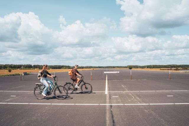 Fietsers op de voormalige landingsbaan van Park Vliegbasis Soesterberg. De foto laat de bijzondere combinatie van fietsen, open landschap en het militaire verleden van het gebied zien.