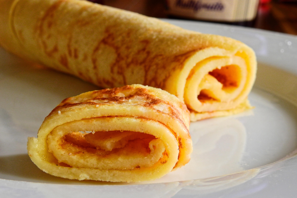Een opgerolde pannenkoek op een bord.