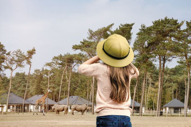 Meisje op safari in Beekse Bergen en spot dieren door haar verrekijker