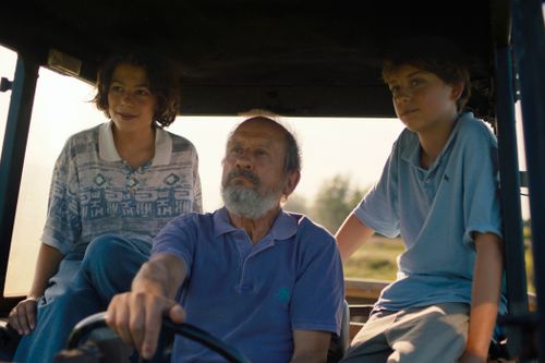Een man en twee kinderen in een tractor