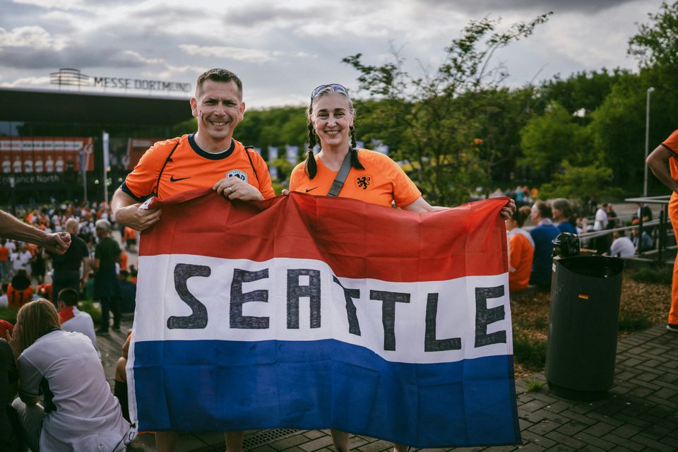 WK Voetbal: oranje fans houden Nederlandse vlag omhoog met daarop het woord Seattle geschreven