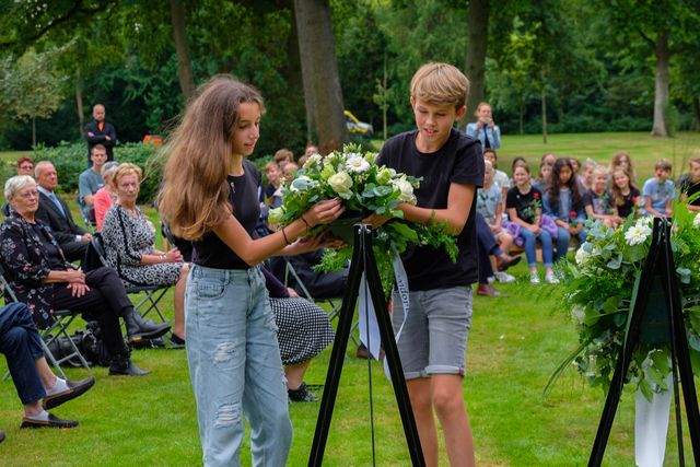 Leerlingen leggen namens BS De Springplank een krans tijdens de herdenking in 2021