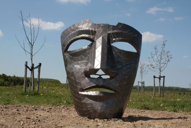 Een groot Romeinse masker als kunstobject in het bos Nieuw Wulven in Houten.