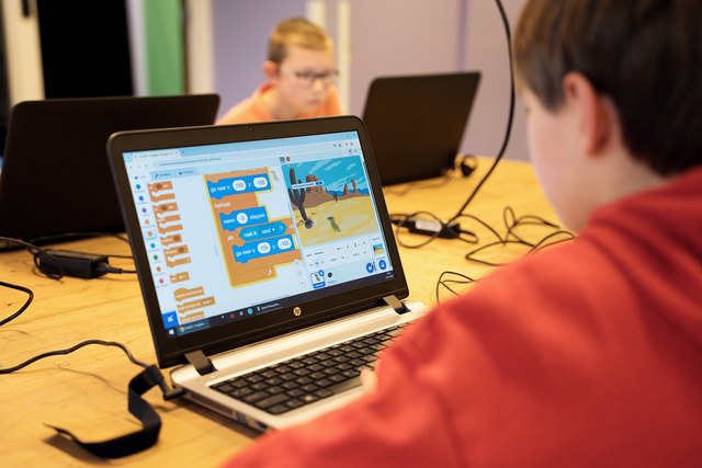 Jongen is bezig met het programma Scratch