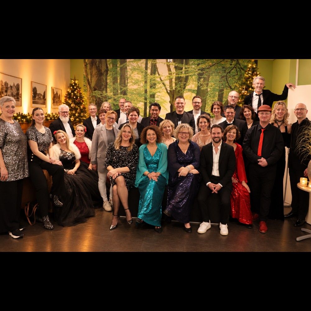Foto van een gezelschap van ongeveer dertig mannen en vrouwen in gala-kleding.