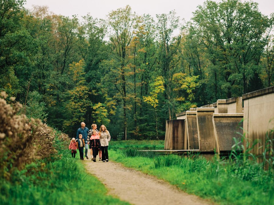 Een gezin loopt langs Deltawerk// in het Waterloopbos