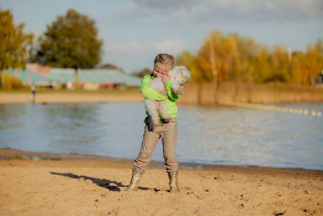 meisje op strand een hondje aan het knuffelen