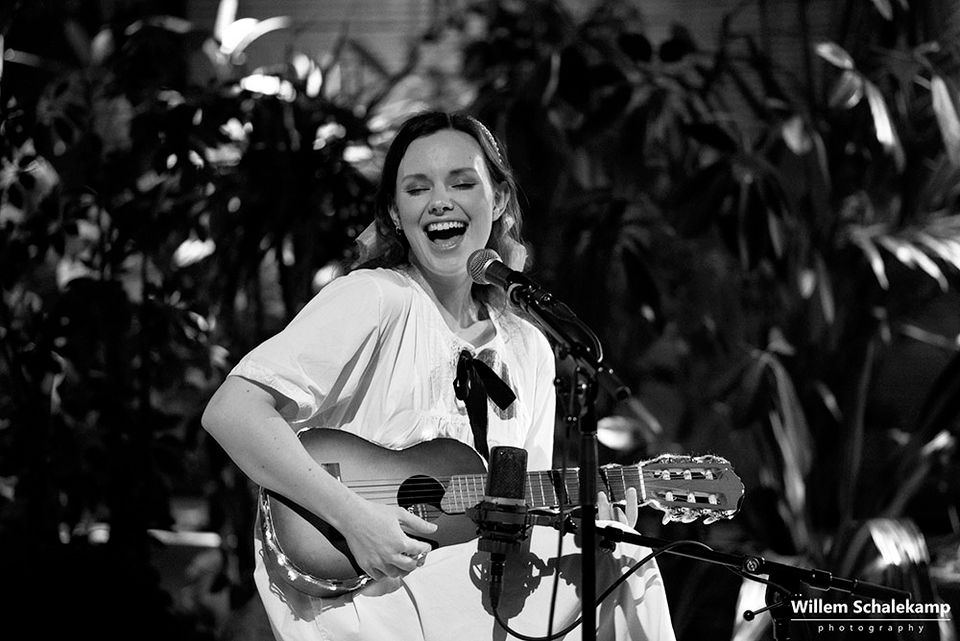 Een vrouw die zingt en gitaar speelt