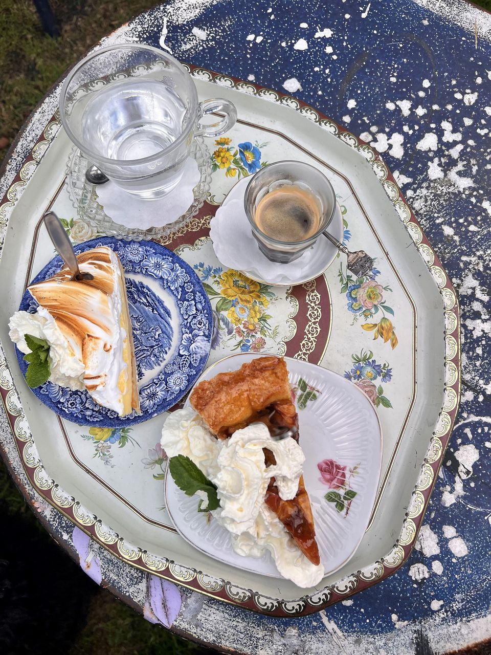 Dienblad met bordjes taart, een kopje koffie en thee