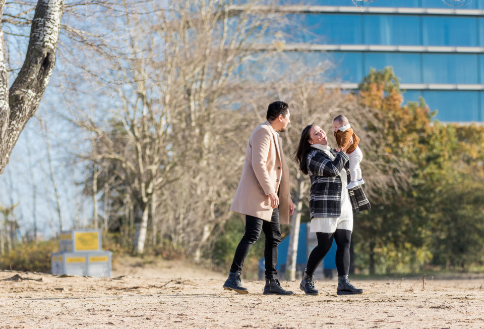 Koppel met baby wandelt over het Almeerderstrand in Almere.